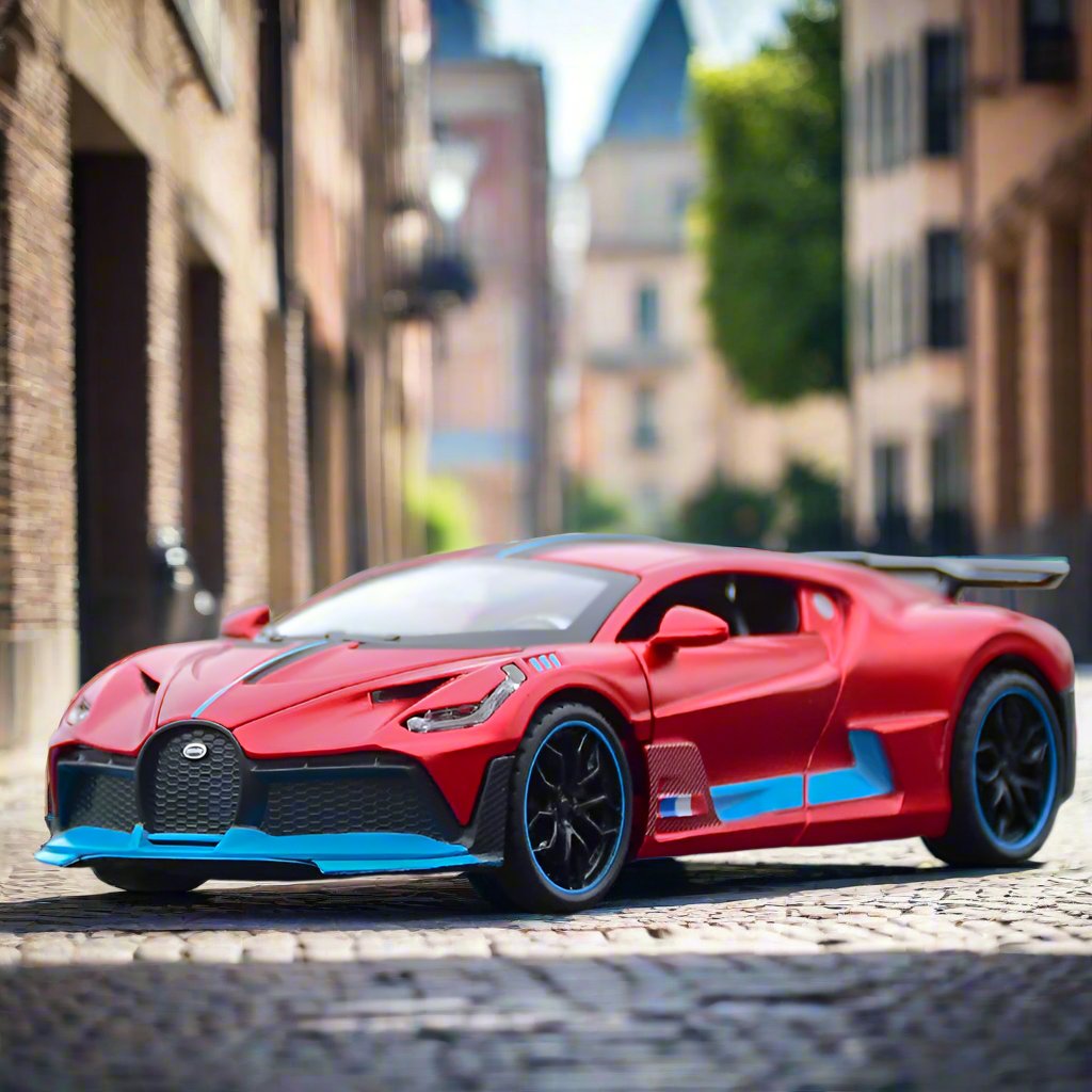 Red die-cast model of a sports car resembling a Bugatti Divo, placed on a scenic mountain road with snowy trees and majestic mountains in the background.